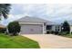Single story home with attached garage and well maintained landscaping at 3812 Nottingham Loop, The Villages, FL 32163