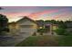 Two-car garage and well-manicured lawn at sunset at 9371 Sw 71St Loop, Ocala, FL 34481