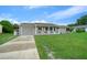 Tan one-story house with a white picket fence and a spacious lawn at 10820 Sw 87Th Ter, Ocala, FL 34481