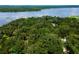 Aerial view showcasing a home near a lake and lush forest at 24750 Ne 177Th Ter, Fort Mc Coy, FL 32134