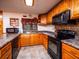 Kitchen with wood cabinets, granite counters, and black appliances at 24750 Ne 177Th Ter, Fort Mc Coy, FL 32134