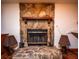 Stone fireplace with brass fire tools and wooden mantel at 24750 Ne 177Th Ter, Fort Mc Coy, FL 32134