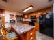 Kitchen with wood cabinets, granite counters, and black appliances at 24750 Ne 177Th Ter, Fort Mc Coy, FL 32134