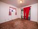 Simple bedroom with carpet, red curtains, and access to an outdoor patio at 24750 Ne 177Th Ter, Fort Mc Coy, FL 32134