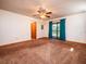 Bright living room with carpet flooring, ceiling fan, and sliding glass doors at 24750 Ne 177Th Ter, Fort Mc Coy, FL 32134