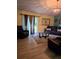 Living room with leather couches, glass coffee table, and sliding glass doors at 6995 Se 22Nd Ave, Ocala, FL 34480
