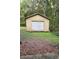 Detached storage shed with white garage door in wooded setting at 6995 Se 22Nd Ave, Ocala, FL 34480