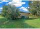 Large backyard with grassy area and home's AC unit at 25 Cedar Ter, Ocala, FL 34472