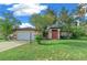 Tan house with orange accents, attached garage, and lush lawn at 25 Cedar Ter, Ocala, FL 34472