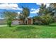 Tan house with orange accents, attached garage, and lush lawn at 25 Cedar Ter, Ocala, FL 34472