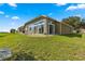 Back exterior view of house showcasing patio and beautiful landscaping at 5676 Sw 40Th Pl, Ocala, FL 34474