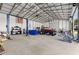 Large workshop featuring a vehicle lift and ample storage at 5615 Nw 202Nd Pl, Mc Intosh, FL 32664