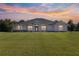 Stunning two-story house with a large lawn under a beautiful sunset at 5615 Nw 202Nd Pl, Mc Intosh, FL 32664
