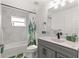 Bathroom with gray vanity, bathtub, and patterned shower curtain at 5615 Nw 202Nd Pl, Mc Intosh, FL 32664