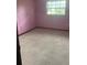 Bright bedroom with pink walls and window at 5601 Se 28Th St, Ocala, FL 34480