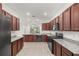 Modern kitchen with dark wood cabinets, granite countertops, and stainless steel appliances at 8546 Sw 79Th Ave, Ocala, FL 34476