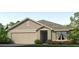 One-story home with beige siding, gray roof, and landscaping at 9872 Se 161St Lane Rd, Summerfield, FL 34491