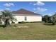 Rear view of house with brown roof, white walls, and landscaping at 5858 Nw 27Th Pl, Ocala, FL 34482