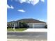 House exterior with three-car garage and palm trees at 5858 Nw 27Th Pl, Ocala, FL 34482