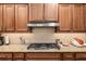 Gas cooktop and stainless steel range hood in a well-lit kitchen at 8445 Sw 93Rd Cir, Ocala, FL 34481