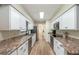 Galley kitchen with white cabinets and stainless steel appliances at 5456 Nw 64Th St, Ocala, FL 34482