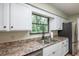 Kitchen with white cabinets, double sink, and stainless steel appliances at 5456 Nw 64Th St, Ocala, FL 34482