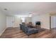 Living room with sectional sofa, two armchairs, and wood-look floors at 5456 Nw 64Th St, Ocala, FL 34482