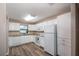 Kitchen features white cabinets, laminate flooring, and modern appliances at 5456 Nw 64Th St, Ocala, FL 34482