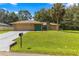 Tan house with teal door, stone accents, and a large grassy yard at 4980 Sw 195Th Ave, Dunnellon, FL 34431