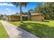 Tan house with teal door, stone accents, and a large grassy yard at 4980 Sw 195Th Ave, Dunnellon, FL 34431