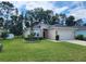 Tan house with two car garage and manicured lawn at 7867 Sw 74Th Loop, Ocala, FL 34481