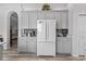 Modern kitchen with gray cabinets, white appliances, and quartz countertops at 12333 Se 177Th Loop, Summerfield, FL 34491
