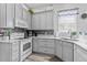 Modern kitchen with gray cabinets, white appliances and quartz countertops at 12333 Se 177Th Loop, Summerfield, FL 34491