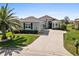 Single-story house with a two-car garage, and nicely landscaped lawn at 12333 Se 177Th Loop, Summerfield, FL 34491