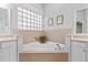 Bathroom featuring a corner bathtub and a large window at 12333 Se 177Th Loop, Summerfield, FL 34491