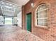 Exterior view of a green door and brick facade near a barn at 6530 Se 156Th Loop # 3 & 4, Summerfield, FL 34491