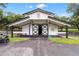 White barn with large doors, covered area, and a paved driveway at 22422 Lake Seneca Rd, Eustis, FL 32736