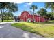 Red barn with a horse trailer parked in front and lush green surroundings at 22422 Lake Seneca Rd, Eustis, FL 32736