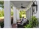 Relaxing front porch with wicker furniture, ceiling fan, and views of nature at 22422 Lake Seneca Rd, Eustis, FL 32736