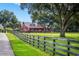 Red barn with American flag mural, seen from across a grassy field with wooden fence at 22422 Lake Seneca Rd, Eustis, FL 32736