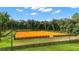 Large riding arena with an orange sand surface, surrounded by a wooden fence at 22422 Lake Seneca Rd, Eustis, FL 32736