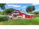 Red barn with metal roof, stone accents, and a second story balcony at 22422 Lake Seneca Rd, Eustis, FL 32736