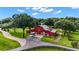 Aerial view of a red barn on a sprawling estate with lush green landscaping and long driveway at 22422 Lake Seneca Rd, Eustis, FL 32736