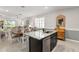 Kitchen island with granite countertop, sink, and dishwasher, open to dining area at 5089 Stokes Way, Wildwood, FL 34785