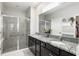 Bathroom with double sinks, granite countertop, and a walk-in shower at 5089 Stokes Way, Wildwood, FL 34785