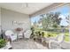 Relaxing screened porch with white wicker furniture and view of backyard at 5089 Stokes Way, Wildwood, FL 34785