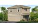 Two-story house with light beige siding, two-car garage, and landscaping at 3184 Evenmore Way, Wildwood, FL 34785