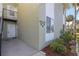 Exterior view of a light-green building with a condo unit entrance and landscaping at 551 Fairways Dr # A, Ocala, FL 34472
