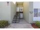 Exterior view of a light-green building with stairs leading to individual condo units at 551 Fairways Dr # A, Ocala, FL 34472