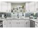 Modern white kitchen with stylish backsplash and marble countertops at 551 Fairways Dr # A, Ocala, FL 34472